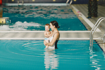 Little cute baby boy. Mother with son. Family playing in a water.