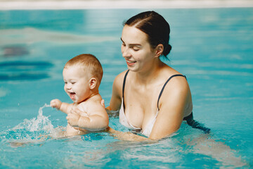 Little cute baby boy. Mother with son. Family playing in a water.