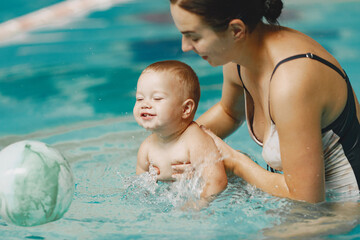 Little cute baby boy. Mother with son. Family playing in a water.