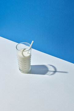 Organic milk in a glass with papercraft straw.
