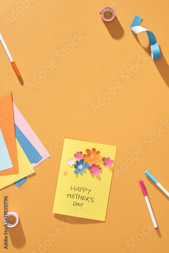 Paper crafts for mother's day. Small child doing a bouquet of flowers out of colored paper for mom. Simple gift idea. view top, copy space