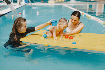 Little cute baby boy. Instructor with kid. Mother with son.