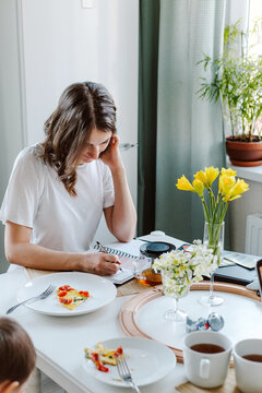 Female working while breakfast, staying at home while isolation