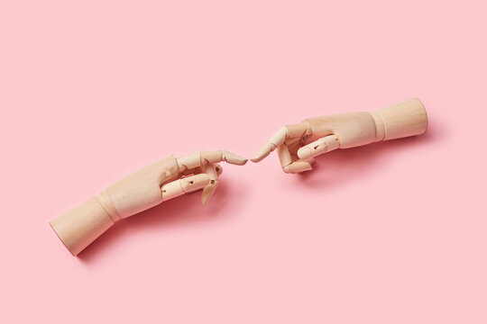 Two wooden dummy fingers touching.