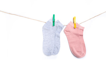 several colored socks hanging on a rope with clothespins isolated on white background