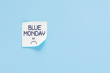 Blue monday text with sad smiley face. Sticker on blue wall. Most depressing and saddest day of the year. Blue monday concept. Copy space. 