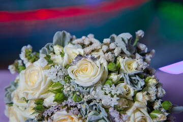 Gold rings for a wedding on a bouquet of flowers. White wedding rose bouquet . Bouquet of white roses.