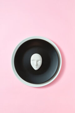 Round plate frame with face mask.