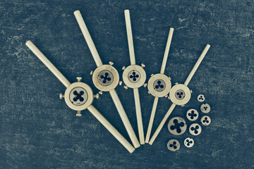 Threading dies, Old used kit for cutting an external thread, close up, top view, stylized