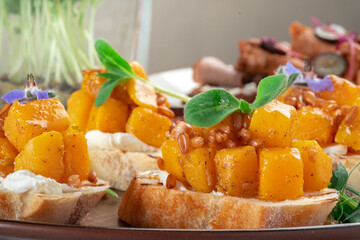 Vegetarian appetizer, Bruschetta with grilled pumpkin, cheese and pearl barley on toasted bread, close up
