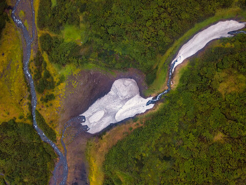 Aerial view from drone above snowy ravine and green trees in Kamchatka krai.