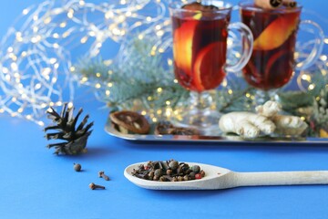 Traditional Christmas drink, cups with mulled wine, spices, fir branches and illumination on a dark background, the concept of home comfort, winter holidays celebration