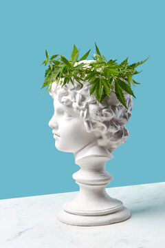 Gypsum boy's statue with cannabis wreath.