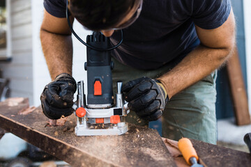 A router in use to clean up carved grooves in wood