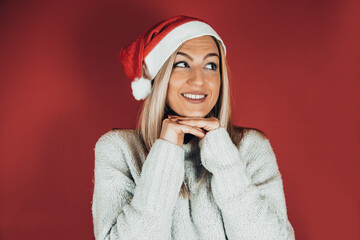 Attractive smiling woman posing on a red background. Christmas and New Year concept.