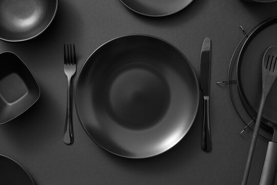 Kitchen table served with black utensils.