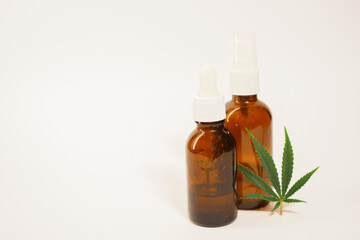 Glass bottles with cbd oil. Cannabis leaf. Medical marijuana threatment. White background. Copy space