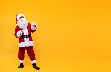 Weihnachtsmann vor gelben Hintergrund zeigt mit den Fingern nach oben 