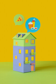 Handmade paper house with food signs above.