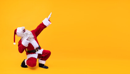 Weihnachtsmann vor gelben Hintergrund zeigt mit den Fingern nach rechts oben