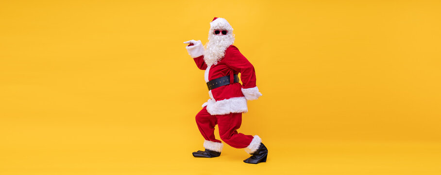 Weihnachtsmann tanzt fr&ouml;hlich wie ein &Auml;gypter vor gelben Hintergrund