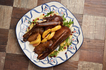 Roasted duck with quince on wooden table background