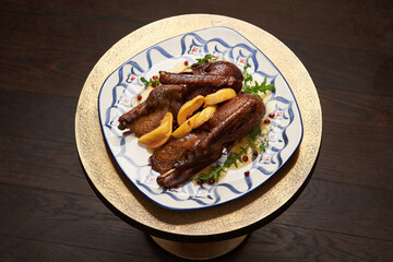 Roasted duck with quince on wooden table background