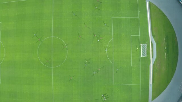 top shot . football players play football in a large stadium. players in red and blue uniforms play against each other. aerial filming from above. 4k aerial view soccer