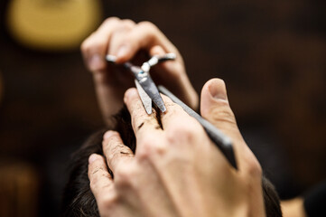 the process of men's haircuts in a stylish barbershop. men's hairdresser, beauty salon. close-up of the hands of a master who cuts a man with scissors. hairdressing accessories. stylish hairstyle