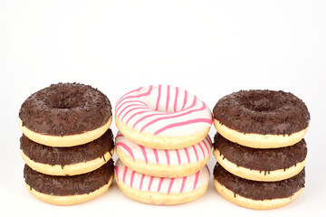 Three stacks of donuts in chocolate and white glaze. Three donuts in each tower.