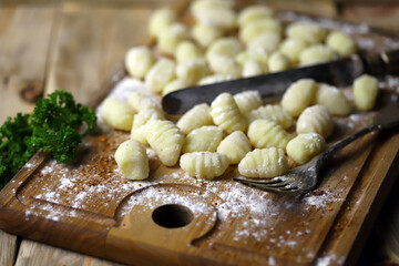 Raw gnocchi on a wooden board. Cooking gnocchi. Italian Cuisine.