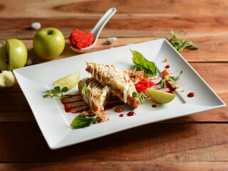 Apple pie with Basil served in a white plate on a rustic wooden table, selective focus