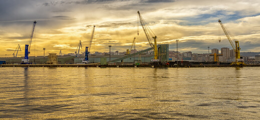 Fototapeta na wymiar a view of the industrial port and harbor in La Coruna in golden morning light
