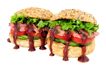 Steak meat and salad sandwiches with barbecue sauce in multi seed topped bread rolls isolated on a white background