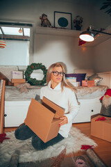 Attractive smiling woman preparing Christmas gifts for friends and family. New Year concept.