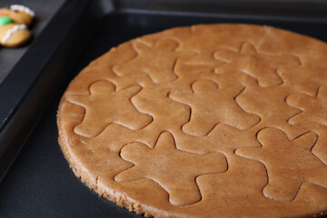 Making homemade gingerbread man cookies in baking dish, closeup
