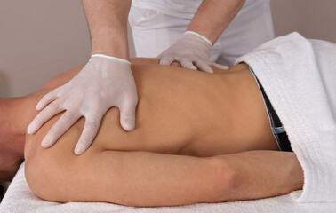 Man having chiropractic back adjustment. Sanitation and hygiene during COVID-19 Pandemic, following Safety protocols