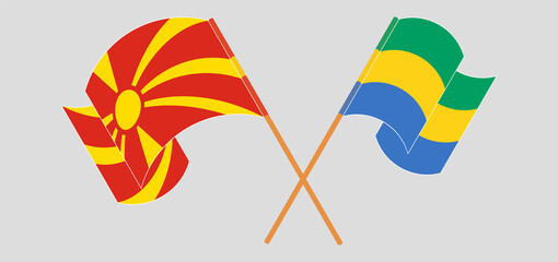 Crossed and waving flags of North Macedonia and Gabon