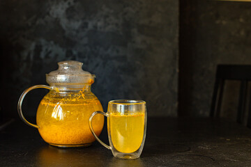 tea sea ​​buckthorn in a teapot and in a transparent cup on the table christmas new year hospitality drink healthy meal snack ingredient top view copy space for tex