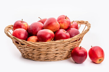 Red apples in a wicker basket. Isolate on white background