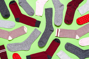 Many socks on a green background above view. Pattern with multicolored socks