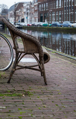 Abandoned rattan armchair near the canal, Leiden, Netherlands