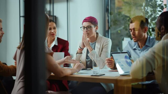 Office Meeting in Conference Room: Beautiful Specialist with Short Pink Hair Talks about Firm Strategy with Diverse Team of Professional Businesspeople. Creative Start-up Team Discusses Big Project 