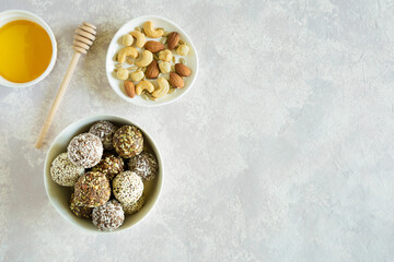 Healthy vegetarian balls with cashews, hazelnuts, peanut butter and almond with honey in bowl flat lay on light background with copy space. Vegetarian, organic food.