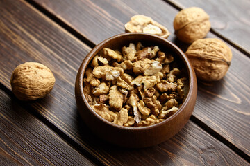 Walnut half and seeds and bowl on wooden table