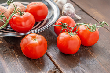 tomatoes, onions and garlic on an old wooden surface