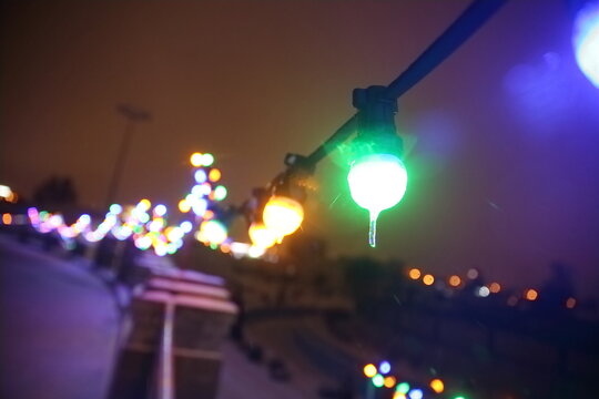 blurred image of festively lit city street on Christmas eve