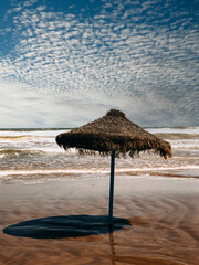 Lonely straw umbrella on seashore