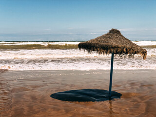 Lonely straw umbrella on seashore