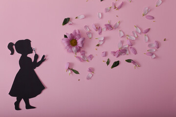 silhouette of a little girl with flowers on a pink background